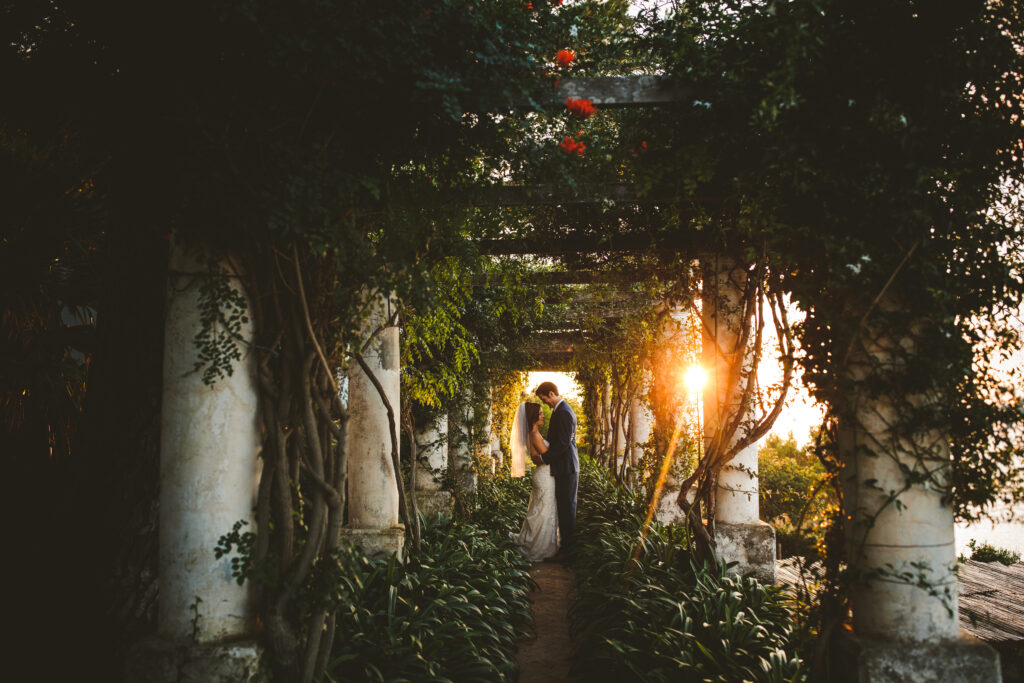 A couple embraces in an Italian courtyard at golden hour. Photo by Maison Pestea