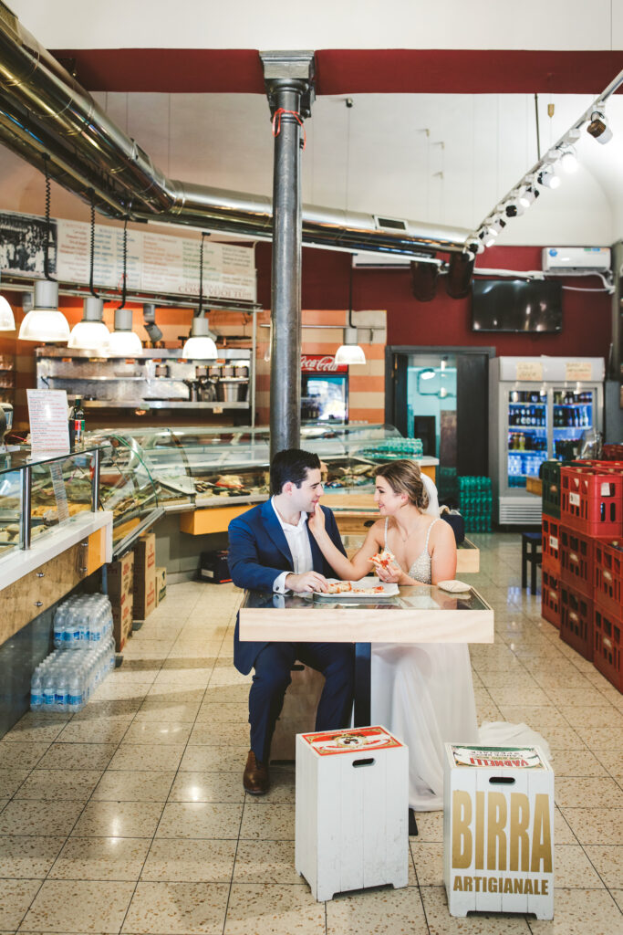 Couple in market eating pizza in Italy by elopement photographer Peggy Picot