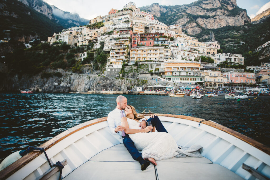 Photo of newlyweds in a boat on the Mediterranean Sea, a classic Positano elopement by Maison Pestea