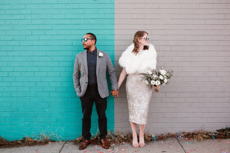 Couple posing in front of colored wall