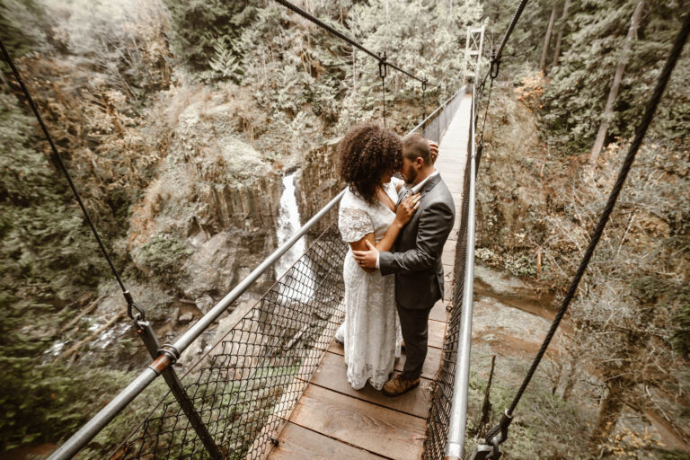 Couple Elopes on suspension bridge above Oregon waterfall