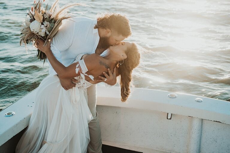 Florida Elopement Photographer Hazography - Art of Eloping. Newlywed couple kissing on boat at sunset.