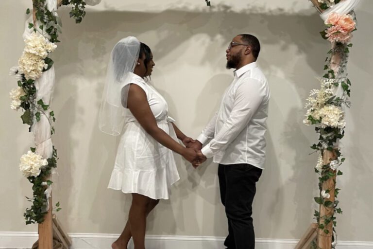 Couple holding hands under wedding arch at Truehart Wedding Chapel outside of Philadelphia