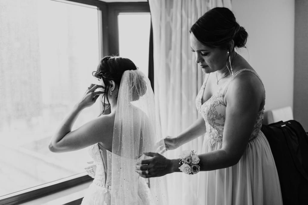 Bride getting ready near window (Weddings by Mylene)